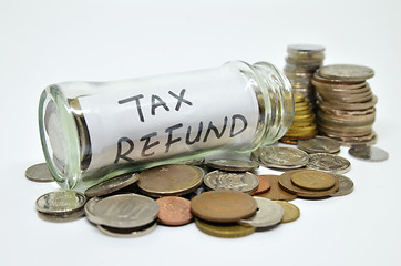 Image showing Tax refund lable in a glass jar with coins spilling out