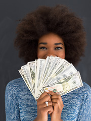 Image showing black woman holding money on gray background