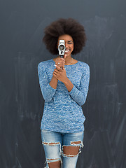 Image showing african american woman using a retro video camera