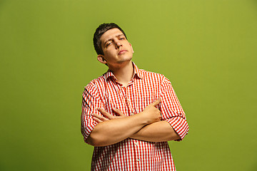 Image showing Let me think. Doubtful pensive man with thoughtful expression making choice against green background