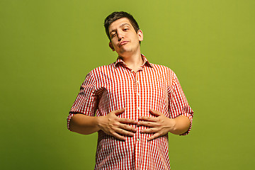 Image showing The happy businessman standing and smiling against green background.