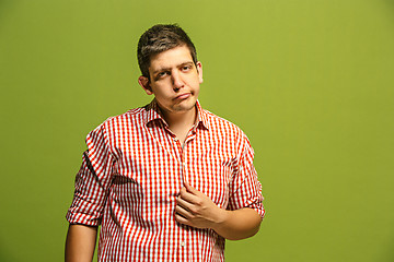 Image showing Beautiful man looking suprised and bewildered isolated on green