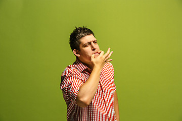 Image showing Isolated on green young casual man shouting at studio