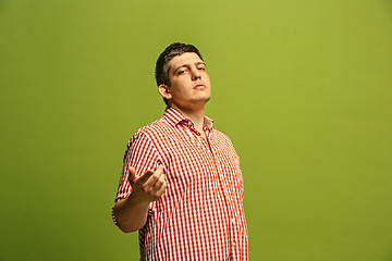 Image showing The happy business man point you and want you, half length closeup portrait on green background.