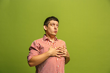 Image showing The happy businessman standing and smiling against green background.