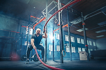 Image showing Men with battle rope battle ropes exercise in the fitness gym.