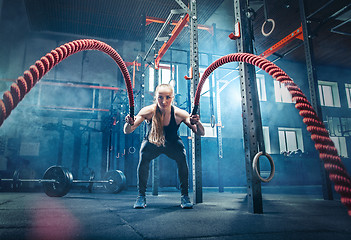 Image showing Woman with battle rope battle ropes exercise in the fitness gym.