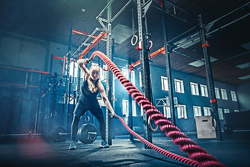 Image showing Woman with battle rope battle ropes exercise in the fitness gym.