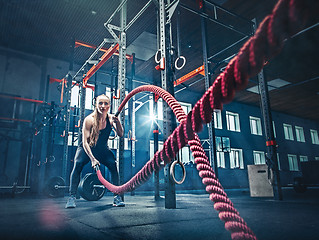Image showing Woman with battle rope battle ropes exercise in the fitness gym.