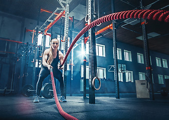 Image showing Woman with battle rope battle ropes exercise in the fitness gym.