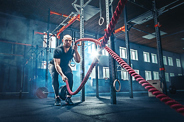 Image showing Men with battle rope battle ropes exercise in the fitness gym.