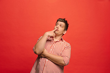 Image showing Beautiful bored man isolated on red background