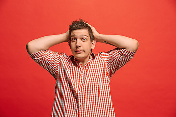 Image showing Man having headache. Isolated over red background.