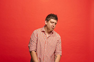 Image showing Beautiful bored man isolated on red background