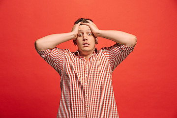 Image showing Man having headache. Isolated over red background.
