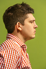 Image showing Beautiful man looking suprised and bewildered isolated on green