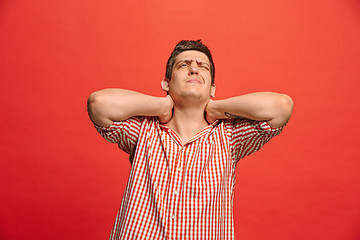 Image showing Man having headache. Isolated over red background.