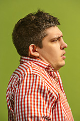 Image showing Beautiful man looking suprised and bewildered isolated on green