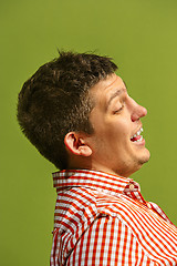 Image showing The happy business man standing and smiling against green background.