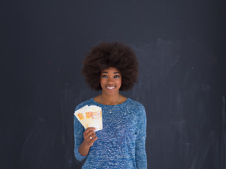 Image showing black woman holding money on gray background