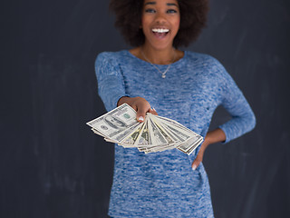 Image showing black woman holding money on gray background