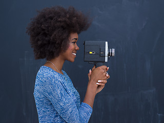 Image showing african american woman using a retro video camera