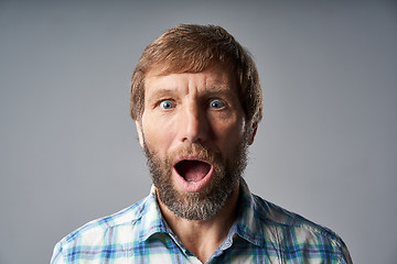 Image showing Surprised mature man in checkered shirt with mouth opened