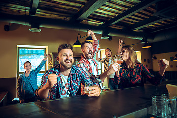 Image showing Sport, people, leisure, friendship and entertainment concept - happy football fans or male friends drinking beer and celebrating victory at bar or pub