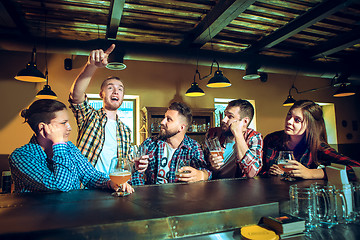 Image showing Sport, people, leisure, friendship and entertainment concept - happy football fans or male friends drinking beer and celebrating victory at bar or pub