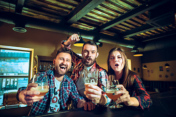 Image showing Sport, people, leisure, friendship and entertainment concept - happy football fans or male friends drinking beer and celebrating victory at bar or pub