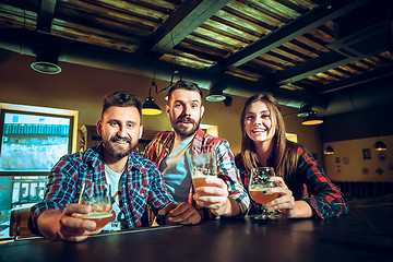 Image showing Sport, people, leisure, friendship and entertainment concept - happy football fans or male friends drinking beer and celebrating victory at bar or pub