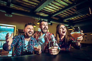 Image showing Sport, people, leisure, friendship and entertainment concept - happy football fans or male friends drinking beer and celebrating victory at bar or pub