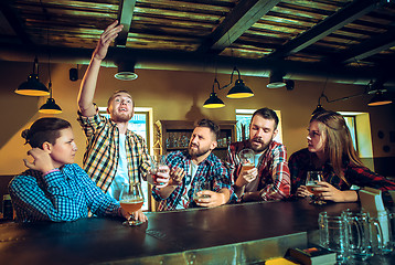 Image showing Sport, people, leisure, friendship and entertainment concept - happy football fans or male friends drinking beer and celebrating victory at bar or pub