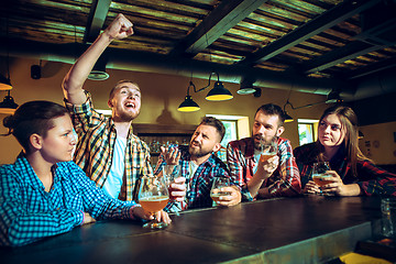 Image showing Sport, people, leisure, friendship and entertainment concept - happy football fans or male friends drinking beer and celebrating victory at bar or pub