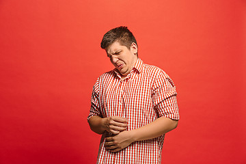 Image showing Let me think. Doubtful pensive man with thoughtful expression making choice against red background