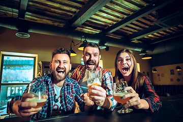 Image showing Sport, people, leisure, friendship and entertainment concept - happy football fans or male friends drinking beer and celebrating victory at bar or pub