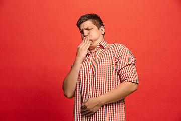 Image showing Let me think. Doubtful pensive man with thoughtful expression making choice against red background