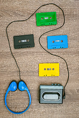 Image showing Vintage walkman, colorful cassetes and headphones on the wooden background