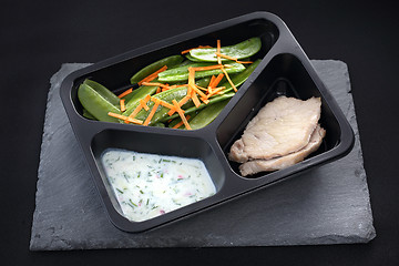 Image showing Cooked meat on a sweet pea salad served with white yoghurt sauce.