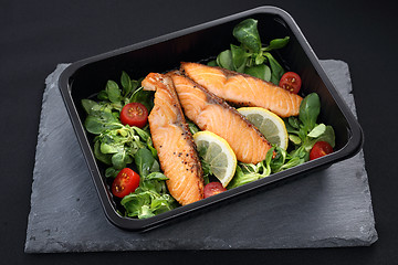 Image showing Pieces of baked salmon on lettuce