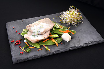 Image showing Cooked meat on a sweet pea salad served with white yoghurt sauce.