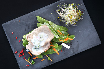 Image showing Lunch. Low-cost, balanced diet. Cooked meat on a sweet pea salad served with white yoghurt sauce.