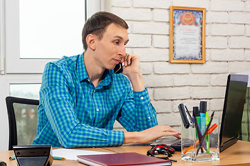 Image showing Dispatcher working in a laptop and talking on the phone