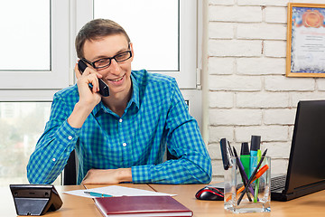 Image showing Office specialist with a smile talking on the phone