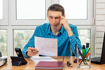 Image showing An office specialist reads the document carefully