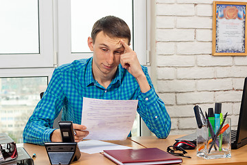 Image showing The office specialist reads the document carefully and thoughtfully