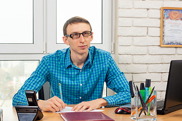 Image showing An office worker looks at the visitor with a thoughtful look