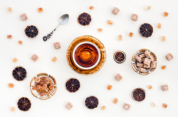 Image showing Cup of tea, brown sugar and dried lemon slices