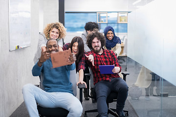 Image showing multiethnics business team racing on office chairs