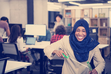 Image showing black muslim software developer making soap bubble